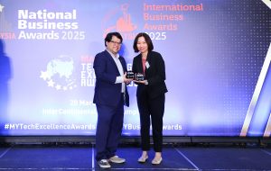 Indy Lau, Chief Operating Officer of Moomoo Malaysia on stage receiving the Malaysia Technology Excellence Award 2025